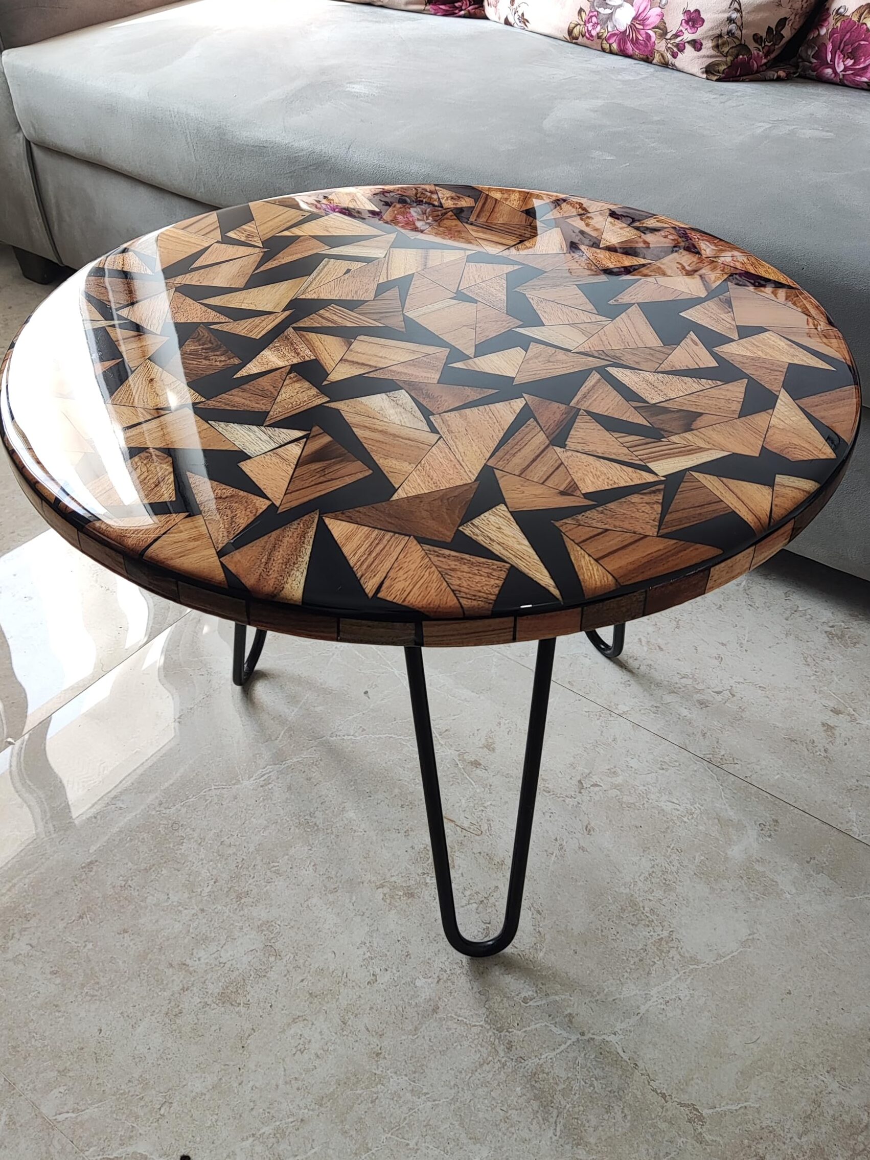 Round wooden mosaic coffee table with glossy resin finish and black metal legs beside a sofa — resin art festive décor.