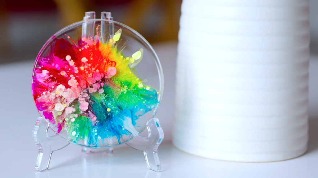 Custom vs Ready-Made Resin Art comparison showing a colorful handmade circular resin art with vibrant rainbow pigments and glossy finish.